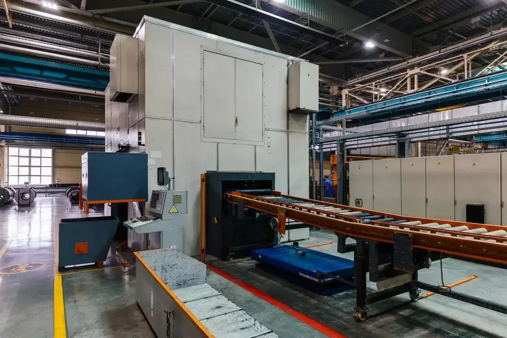 Stamping press conveyor at metalworking factory workshop