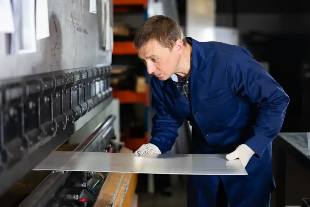 operator positioning metal for bending on machine